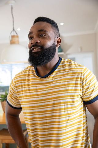Man Arranging Potted Plant in Minimalist Kitchen Space