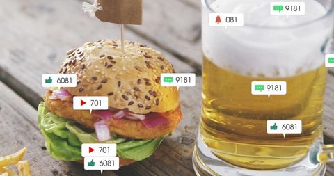 Crispy fish sandwich featuring seeded bun and frosty beer mug on rustic wood table