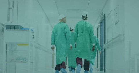 Surgical team navigating hospital corridor in green gowns
