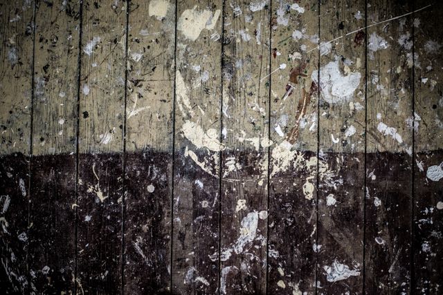 This close-up view of white paint stains on a wooden surface offers a rustic, vintage backdrop ideal for use in interior design, graphic design, and creative arts projects. The worn and distressed texture can add authentic, aged effects to various creative endeavors, serving well as a background for text, digital artwork, advertisements, or website design elements.