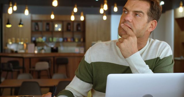 Thoughtful Professional Working on Laptop in Modern Café - Download Free Stock Images Pikwizard.com