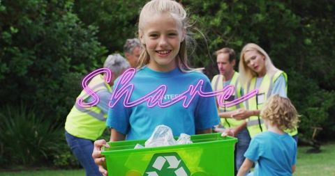 Preteen volunteer smiling holding green recycling bin in park during community cleanup