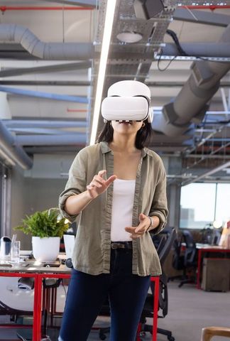 Asian woman wearing vr headset interacting with virtual interface in modern office