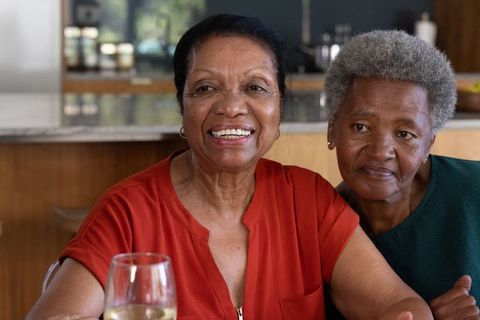 Senior african american women sharing warm laughter and companionship at kitchen table