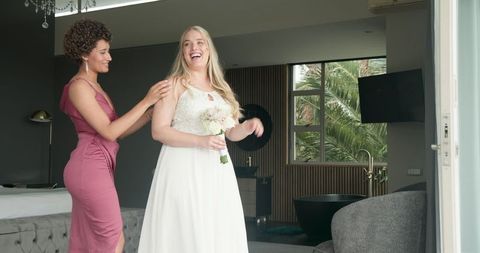 Bride and Bridesmaid Sharing Joyful Moment Before Wedding