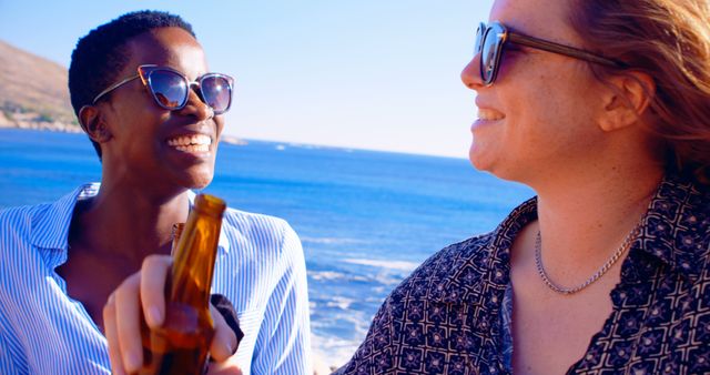 Friends Smiling and Enjoying Drinks by the Sea - Download Free Stock Images Pikwizard.com