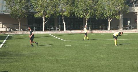 Soccer Players Training on Sunny Green Field Preparing for Match