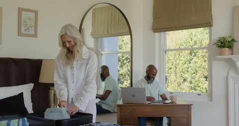Couple packing suitcase in cozy bedroom for special occasion