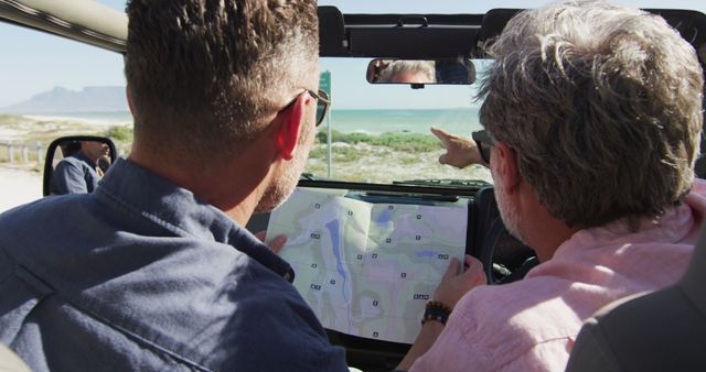 Men Navigating with Map in Convertible Along Coastal Road - Download Free Stock Images Pikwizard.com