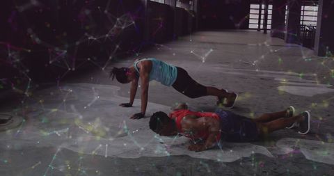 Dynamic Duo Exercising Burpees with Futuristic Digital Network Overlay