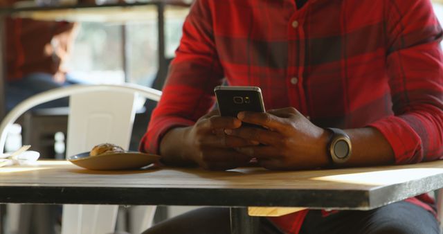 Businessman in red plaid shirt using smartphone indoors - Download Free Stock Images Pikwizard.com