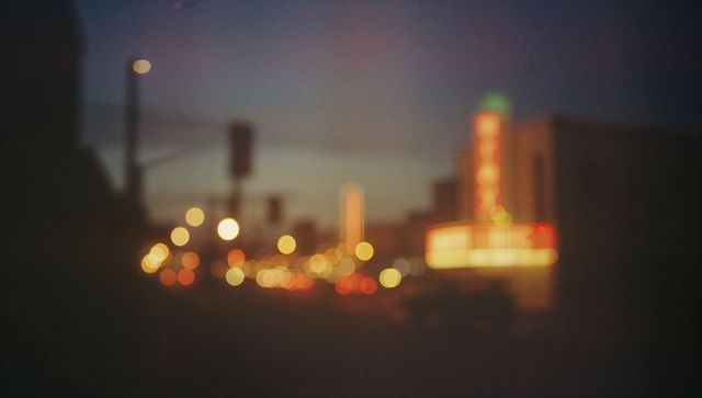 City nightlife blurred neon lights and car headlights bokeh