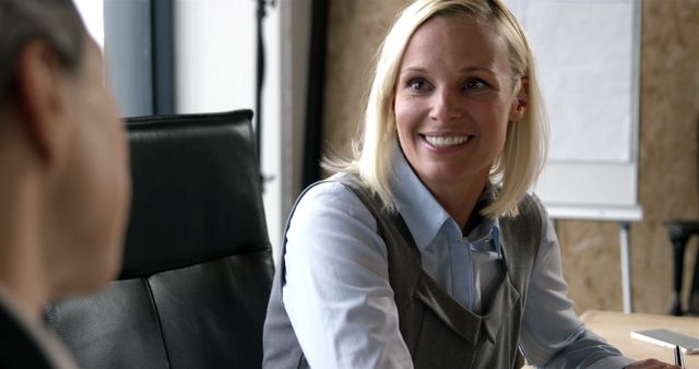 Smiling Businesswoman Engaging In Conversation During Office Meeting - Download Free Stock Images Pikwizard.com