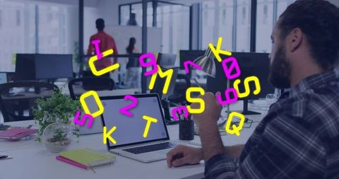 Office worker using smartphone at laptop desk in modern workspace