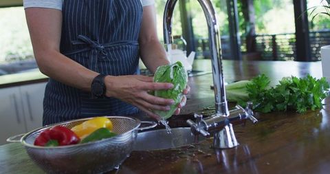 Pregnant Woman Washing Vegetables at Home Kitchen Sink