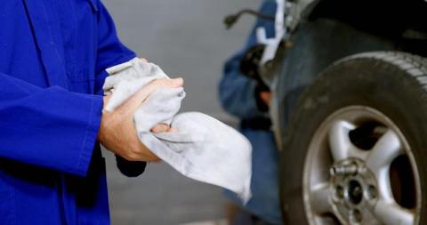 Mechanic Cleaning Hands Next to Car in Workshop - Download Free Stock Images Pikwizard.com