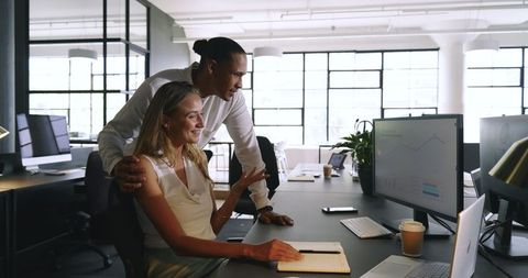 Colleagues Collaborating on Data Analysis at Modern Office