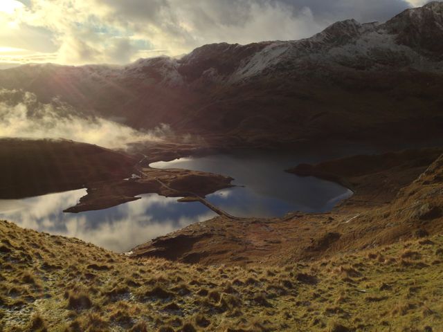 Serene Mountain Lake Scene with Sunlight Breaking Through Clouds - Download Free Stock Photos Pikwizard.com