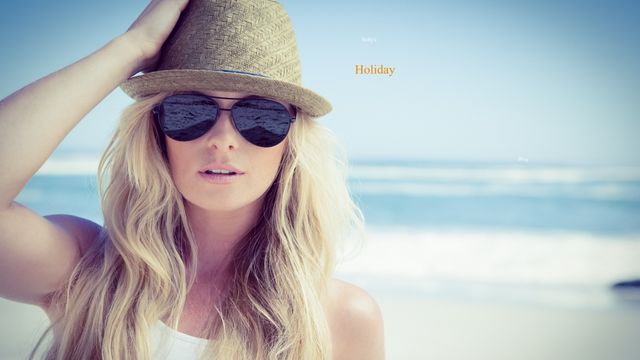 Blonde woman wearing a straw hat and sunglasses enjoying a sunny day at the beach. Perfect for advertisements related to summer vacations, travel brochures, beachwear fashion, or lifestyle blogs focusing on relaxation and coastal activities.