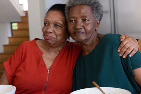 Elder african american women sharing quiet moment at kitchen table showing warm bond