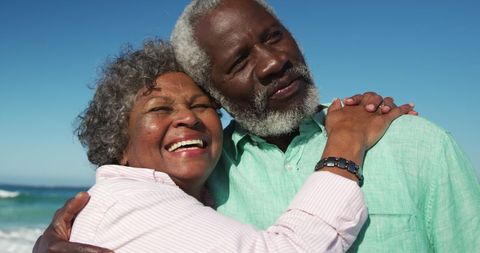 Joyful Senior Couple Embracing at Beach During Relaxing Vacation