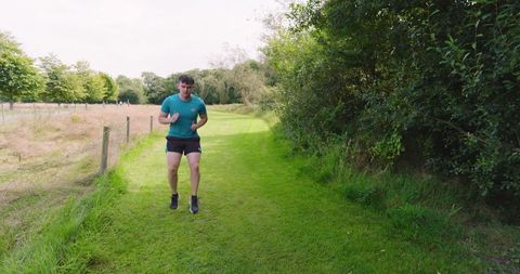Man jogging on grassy path in peaceful nature setting