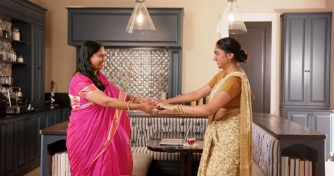 Indian Mother and Daughter Dancing in Modern Kitchen