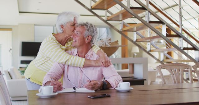 Senior caucasian couple embracing each other calculating finances at home. retirement senior couple lifestyle living