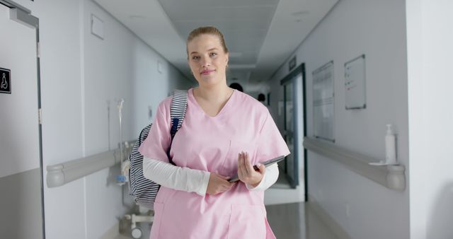 Nurse in Pink Uniform Walking Down Clinic Hallway - Download Free Stock Images Pikwizard.com