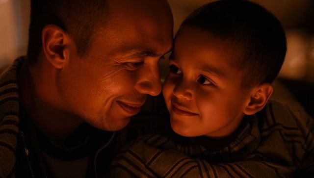 Warm father and son embrace under soft home light conveying intimate family bond