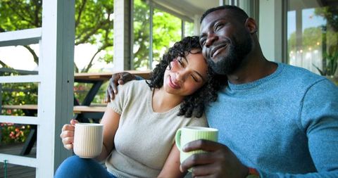 Couple Relaxing on Porch with Coffee Mugs