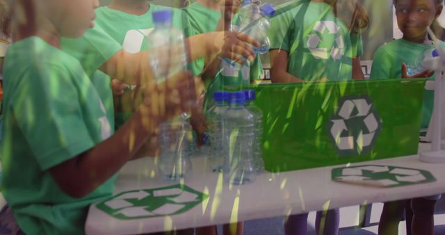 Image of a group of schoolchildren recycling plastic bottles and putting them into a green box with recycling sign and grass moving in the foreground 4k
