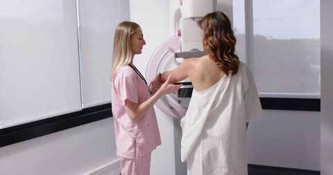 Mammography Technologist Guiding Patient During Breast Screening with Mammogram Machine