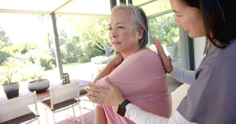 Assisting Senior Asian Woman with Home Physiotherapy