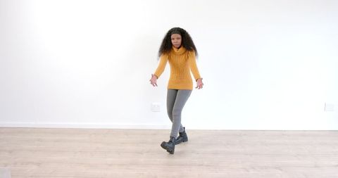 Woman in Cozy Orange Sweater Balancing Indoors