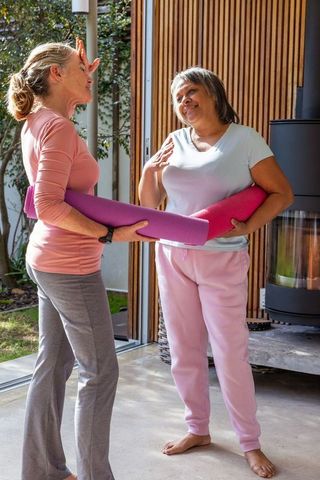 Diverse Female Friends Enjoying Yoga on Patio with Greenery