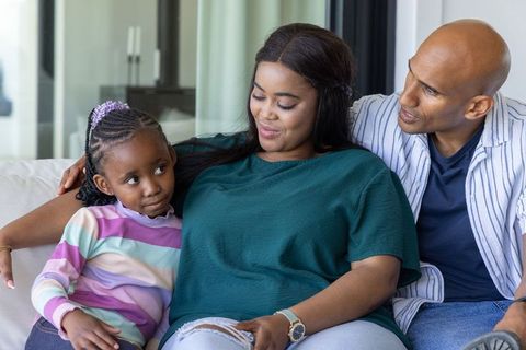 African american family relaxing on sofa sharing tender moment with daughter