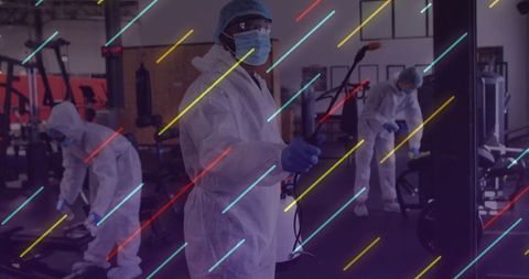 Sanitizing workers disinfecting gym with protective gear