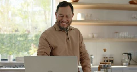 Asian man enjoying morning coffee rituals while working from home