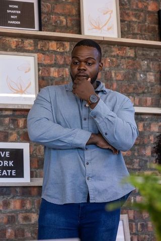 Thoughtful professional man in modern office with motivational decor