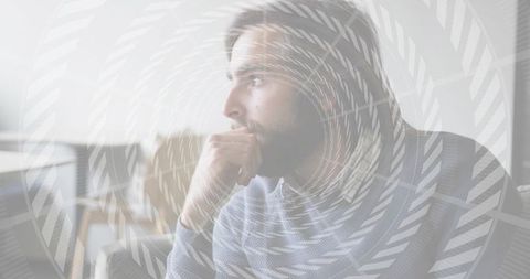 Bearded man contemplating at window with spiral overlay, minimalist interior portrait