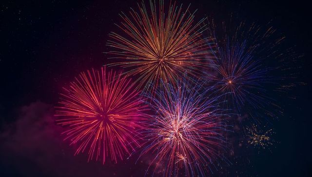 Vibrant Fireworks Bursting against Night Sky