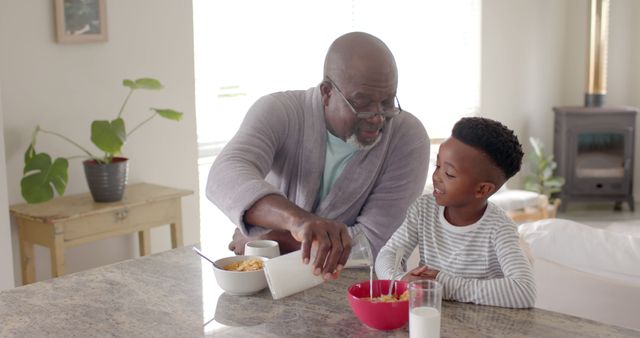 Grandfather Pouring Cereal for Happy Grandson at Breakfast Table - Download Free Stock Images Pikwizard.com