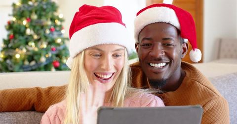 Diverse couple enjoying christmas video call holiday celebration