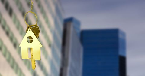 Golden House Key Hanging Over Modern City Skyline