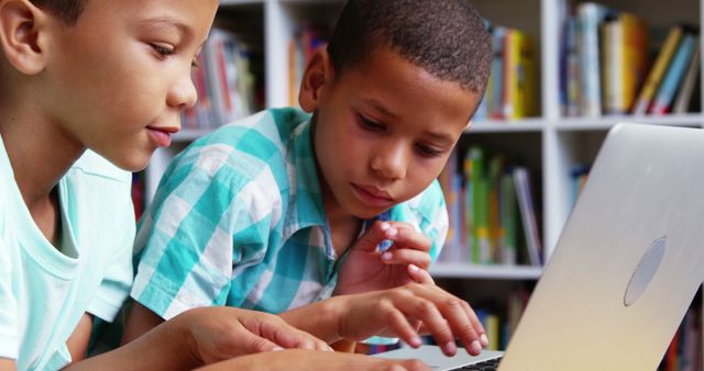 Two Young Boys Learning on Laptop Together in Library - Download Free Stock Images Pikwizard.com