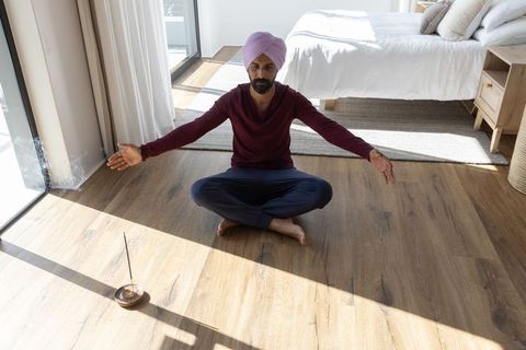 Man with Turban Meditating in Sunlit Modern Bedroom with Incense