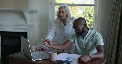 Middle aged couple planning wedding merger using technology at home