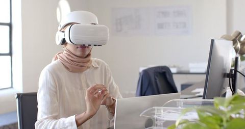 Woman Engaging VR Technology with Laptop in Modern Office