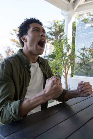 Determined african american man clenching fists outdoors
